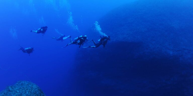 Group of Scuba divers Deep Diving around Gozo